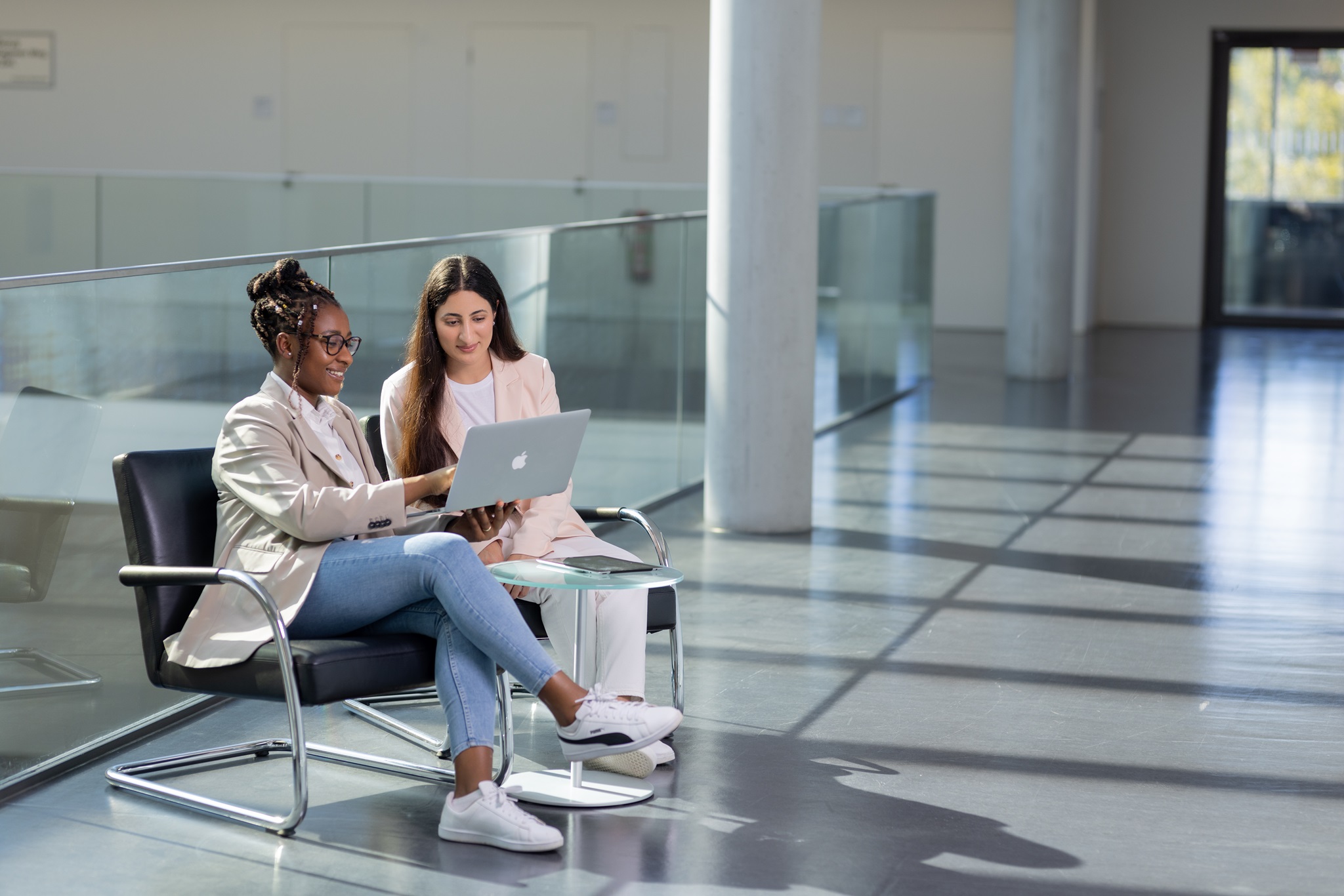 zwei Junge Frauen in einer Sitzgruppe mit Laptop