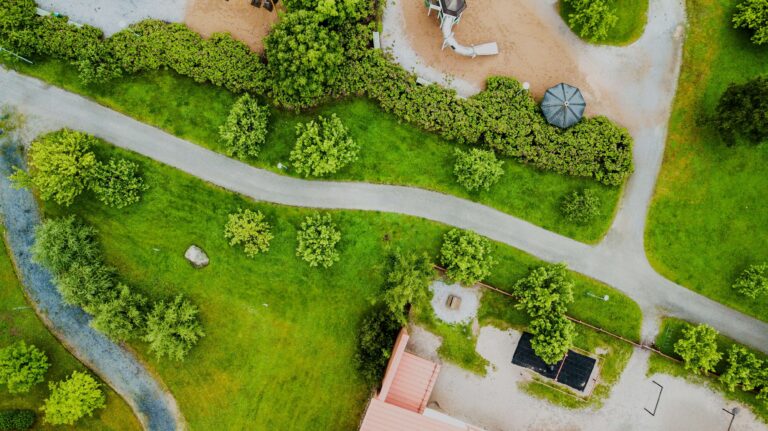 Eine Straße führt durch eine grüne Landschaft mit grünen Wiesen und Bäumen.