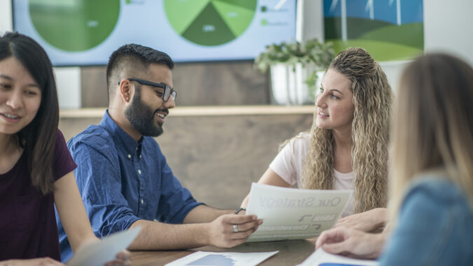 Work colleagues discuss trends in sustainable technologies.